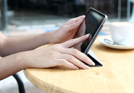 asian woman working touch her tablet and search information at coffee shop