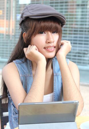 Image of asian student working her job with tablet at coffee shopの写真素材