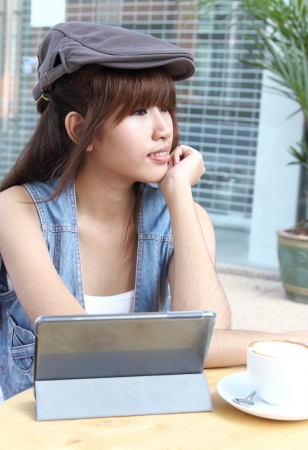 Image of asian student working her job with tablet at coffee shopの写真素材