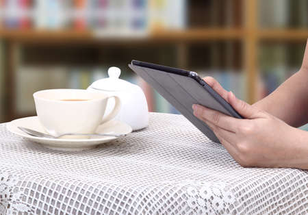 Closeup images of asian woman touch her tablet and hot coffee の写真素材
