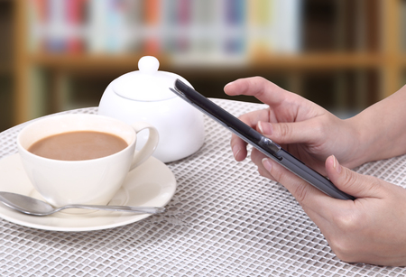 Closeup images of asian woman touch her tablet and hot coffee の写真素材