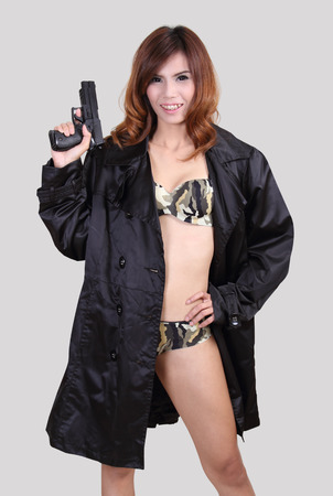 asian woman in sexy bikini holding a gun on her handの写真素材