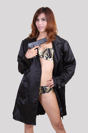 asian woman in sexy bikini holding a gun on her handの写真素材