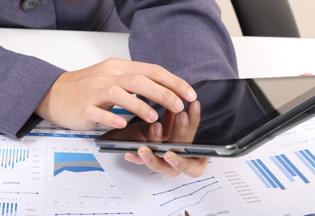 closeup image of business woman touch tablet for working on white deskの写真素材
