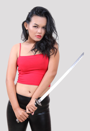 asian woman in red and black cloth holding samurai sword の写真素材