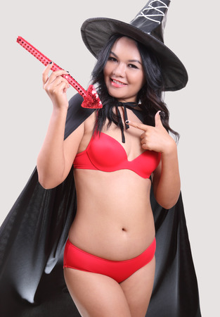 Image of portrait asian woman in red bikini and black hat on halloweenの写真素材