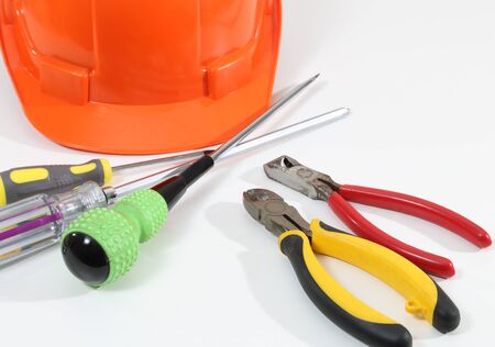 Image of helmet pliers tools and business report for construction on white deskの写真素材