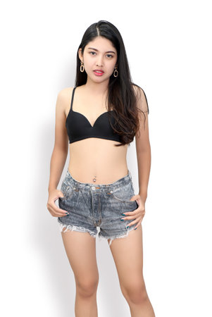 image of woman with black bra and jeans on white background in studioの写真素材
