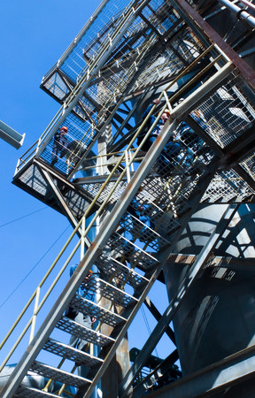 Industrial zone, man climbing staircaseの写真素材