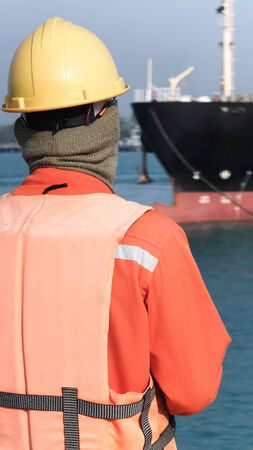 Port worker looking oil bargeの写真素材