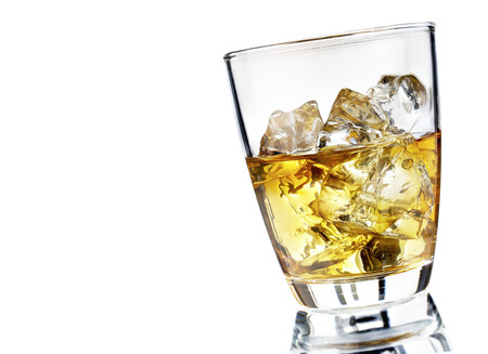 Glass of scotch whiskey and ice on a white backgroundの写真素材