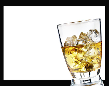 Glass of scotch whiskey and ice on a white backgroundの写真素材