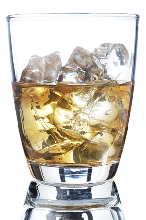 Glass of scotch whiskey and ice on a white backgroundの写真素材