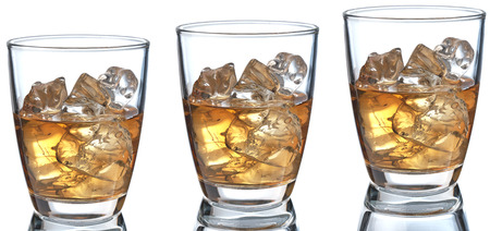 Glass of scotch whiskey and ice on a white backgroundの写真素材