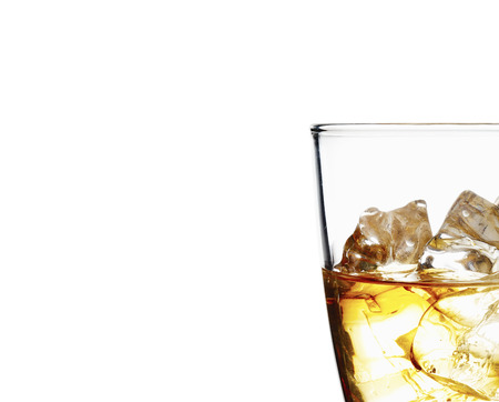 Glass of scotch whiskey and ice on a white backgroundの写真素材