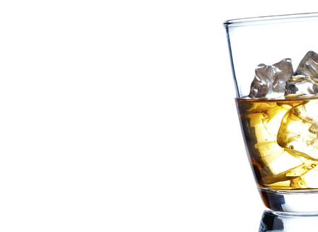 Glass of scotch whiskey and ice on a white backgroundの写真素材