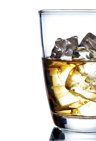 Glass of scotch whiskey and ice on a white backgroundの写真素材