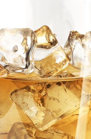 Glass of scotch whiskey and ice on a white backgroundの写真素材
