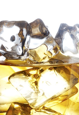 Glass of scotch whiskey and ice on a white backgroundの写真素材