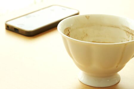 coffee cup And Telephone On The wood Table by the window with ornaments empty.の写真素材