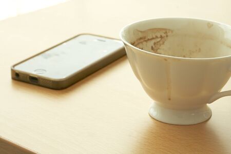 coffee cup And Telephone On The wood Table by the window with ornaments empty.の写真素材