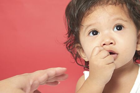 Portrait of one year old baby red backgroundの写真素材
