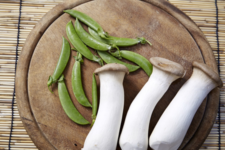 Peas with mushrooms, wooden chopping boardの写真素材