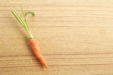 Bunch of baby carrots isolated on wooden backgroundの写真素材