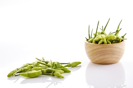 green peppers, Karen green peppers in a wooden bowl isolated on white background.の写真素材