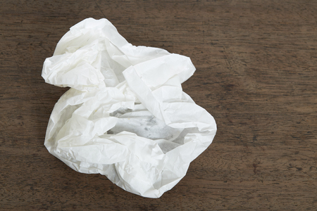 White Crumple paper ball on old wood deskの写真素材