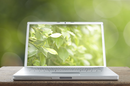 Aluminum Laptop stands on a wooden table isolated white black display - front Viewの写真素材