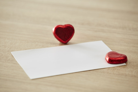 Blank sheet of paper with hearts on rustic wooden table backgroundの写真素材