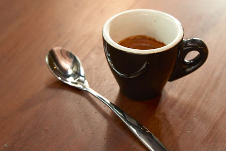 Black cup of coffee on old wooden tableの写真素材