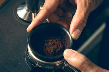 Man tamping fresh morning coffeeの写真素材