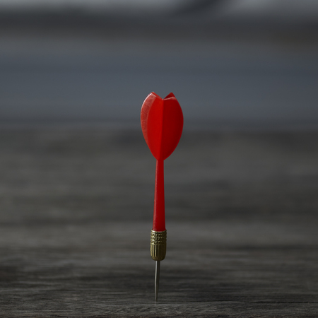 red dart on the brown wooden backgroundの写真素材