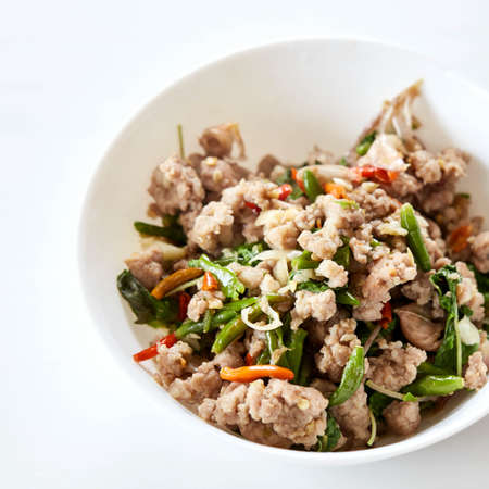 stir fried pork with basil in dish and rice in plate on table on white wooden background. Thai foodの写真素材