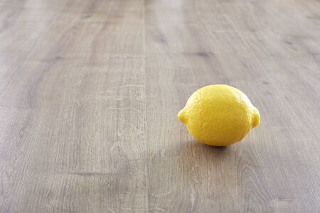 Fresh Single yellow lemon on wooden tableの写真素材