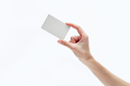 Female hand holding card isolated on whiteの写真素材