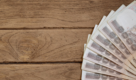One hundred baht bills on the old wooden