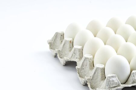 White eggs of a hen in harmless, cardboard packing on a white background.の写真素材