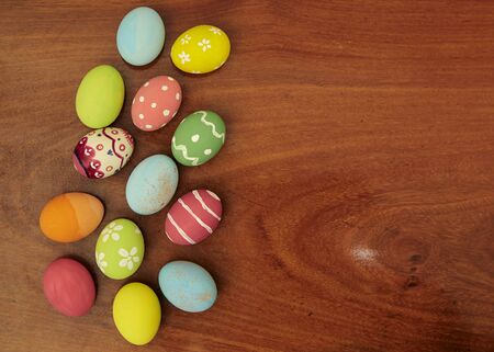 Colorful Easter eggs on wooden background with copy space.