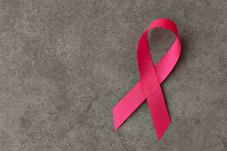 Pink breast cancer ribbon on gray background, minimal conceptの写真素材