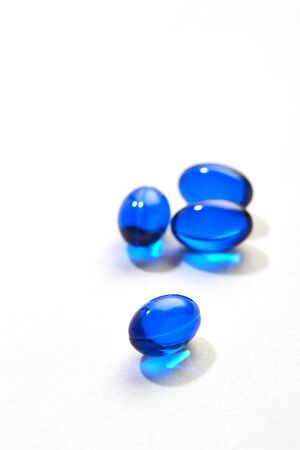 Blue pills capsule isolated on white backgroundの写真素材