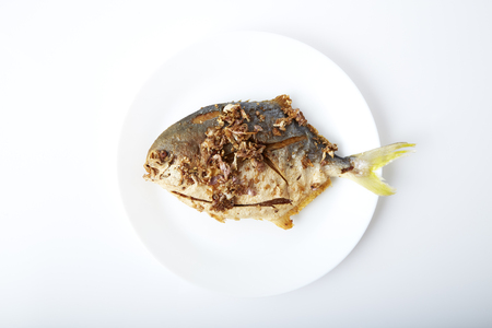Fresh pomfret deep fried in dish isolated in white background clipping path の写真素材