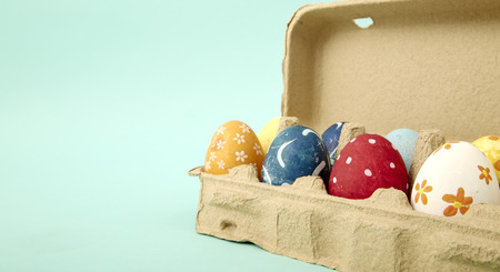 Coloeful easter eggs in nest on pastel blue color background with space, minimal design Easter...