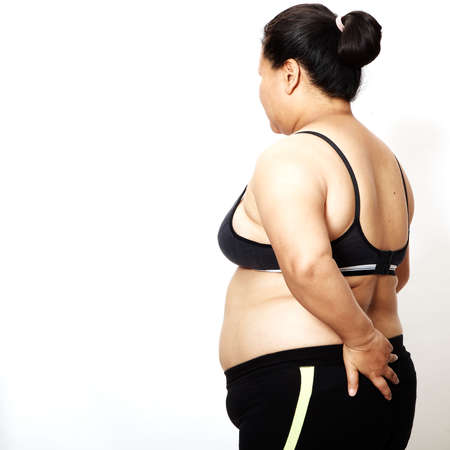 Woman measuring her waistline fat tummy on white background,obese womenの写真素材