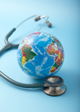 World health day ,Stethoscope wrapped around globe on pastel blue background. Save the wold, Global health care and Green Earth day conceptの写真素材