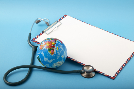 World health day ,Stethoscope wrapped around globe on pastel blue background. Save the wold, Global health care and Green Earth day conceptの写真素材