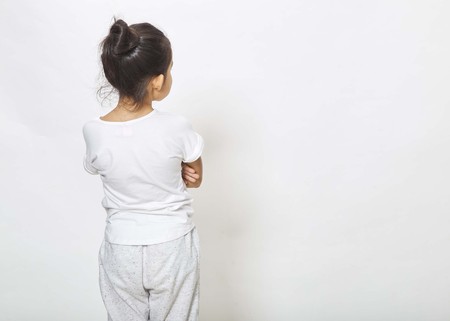Back view of little girl looking at wall. Rear view on white background, Back to school conceptの写真素材