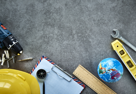 Construction hat with ruler placed on high angle table, International Labor Day concept